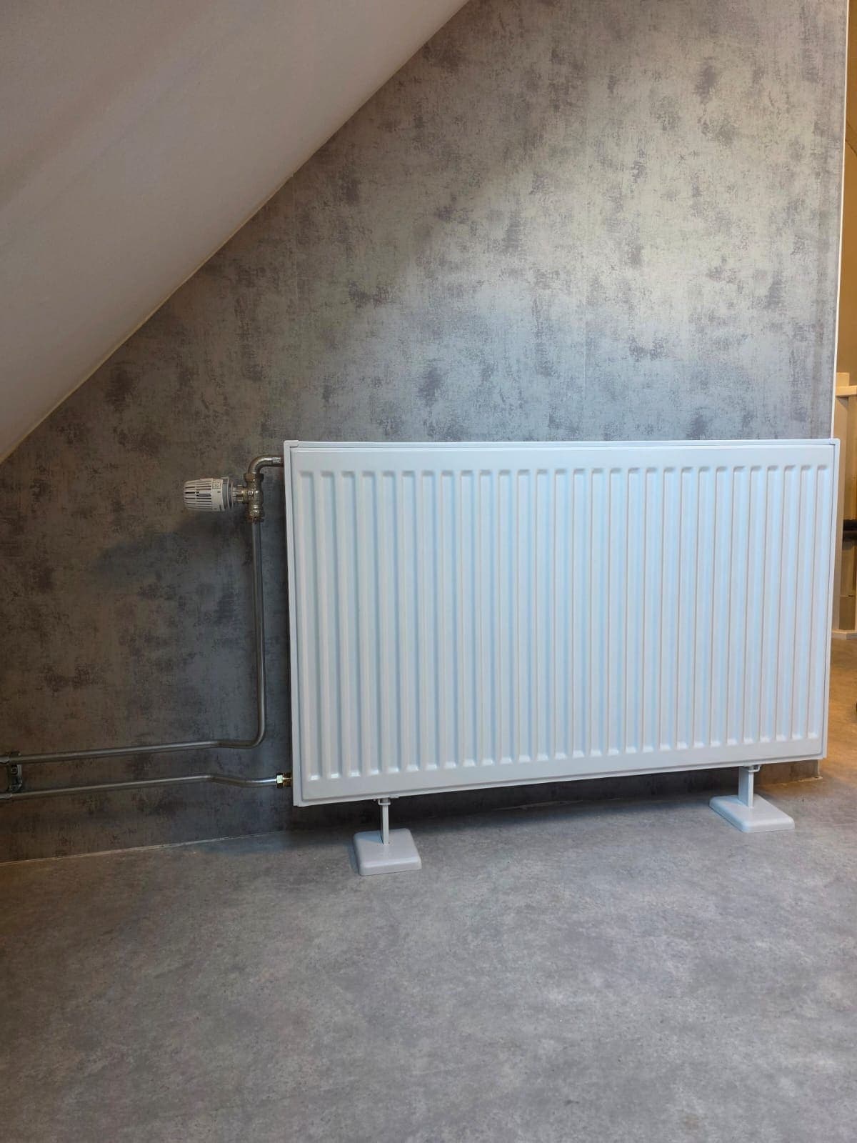 Nieuwe radiator geplaatst tegen een lichte wand in een woonkamer in Almelo