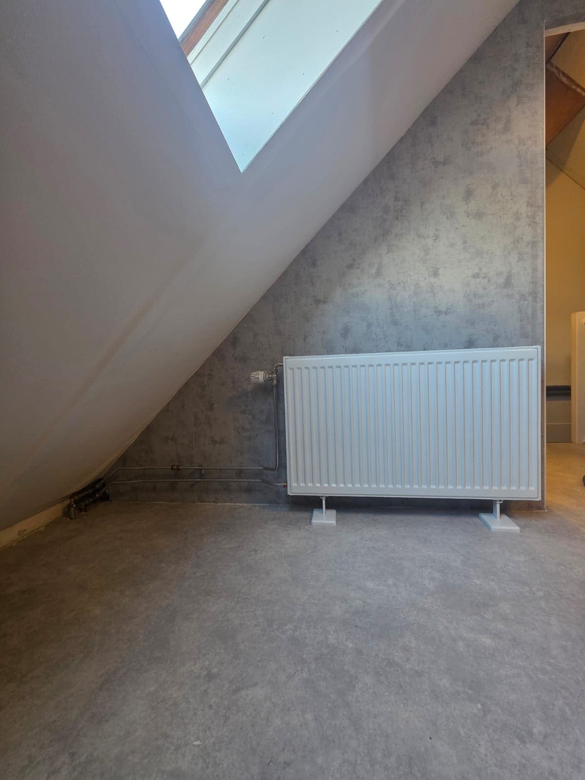 Radiator onder een schuin dak in een slaapkamer in Almelo