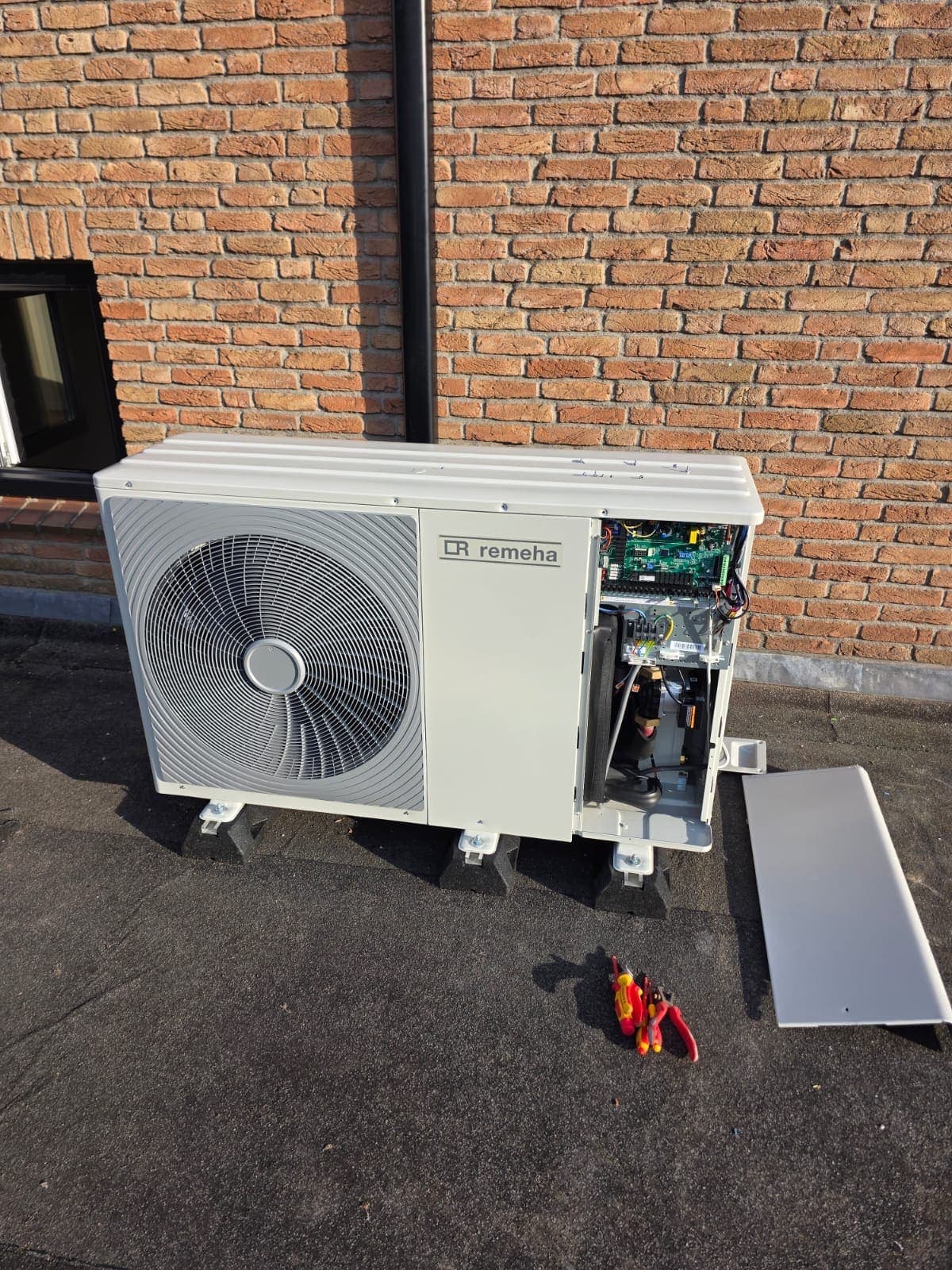 Buitenunit van een warmtepomp die wordt gemonteerd bij een woning in Almelo