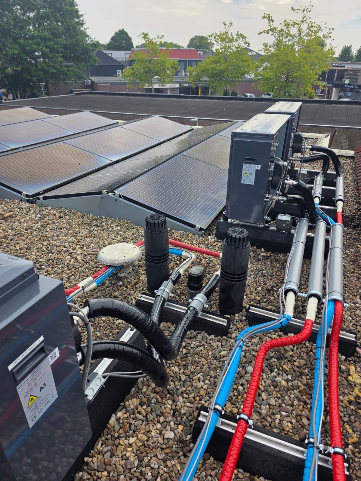 Warmtepompen naast zonnepanelen op een plat dak in Almelo